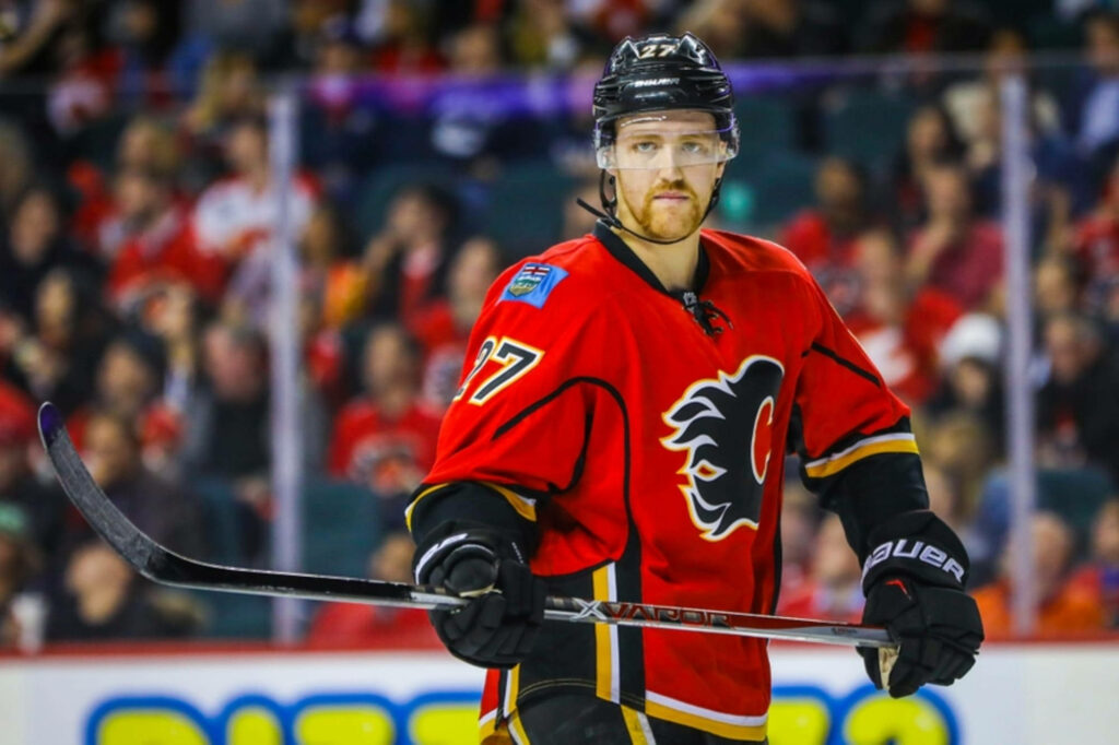 Dougie Hamilton in Calgary Flames uniform poised on ice ready for intense hockey action background Wallpaper