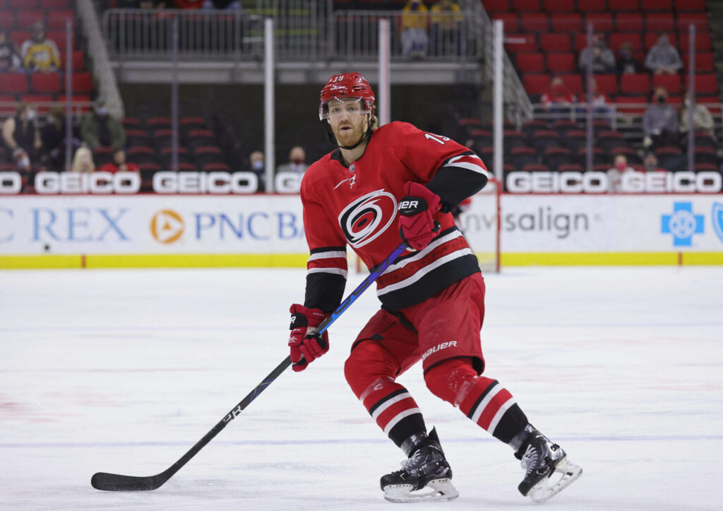 Dougie Hamilton Carolina Hurricanes in red jersey intense ice hockey action vs Pittsburgh Penguins Wallpaper