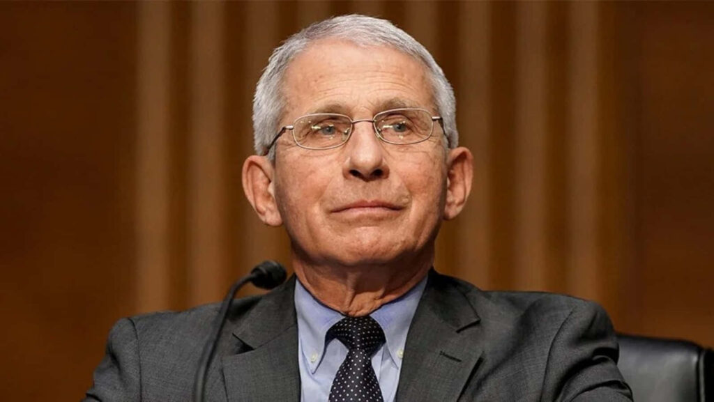 Dr Anthony Fauci speaking confidently on public health in a professional setting wallpaper background