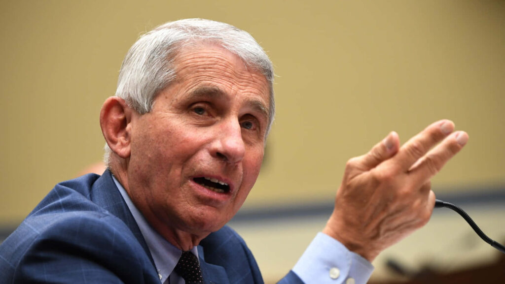 Dr Anthony Fauci speaking passionately during a formal speech with wallpaper background