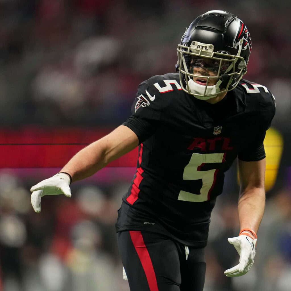 Atlanta Falcons wide receiver Drake London in action wearing black red uniform stadium background Wallpaper