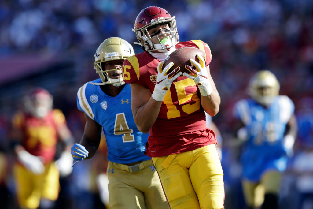 Drake London catching football in red gold uniform intense game action stadium wallpaper background