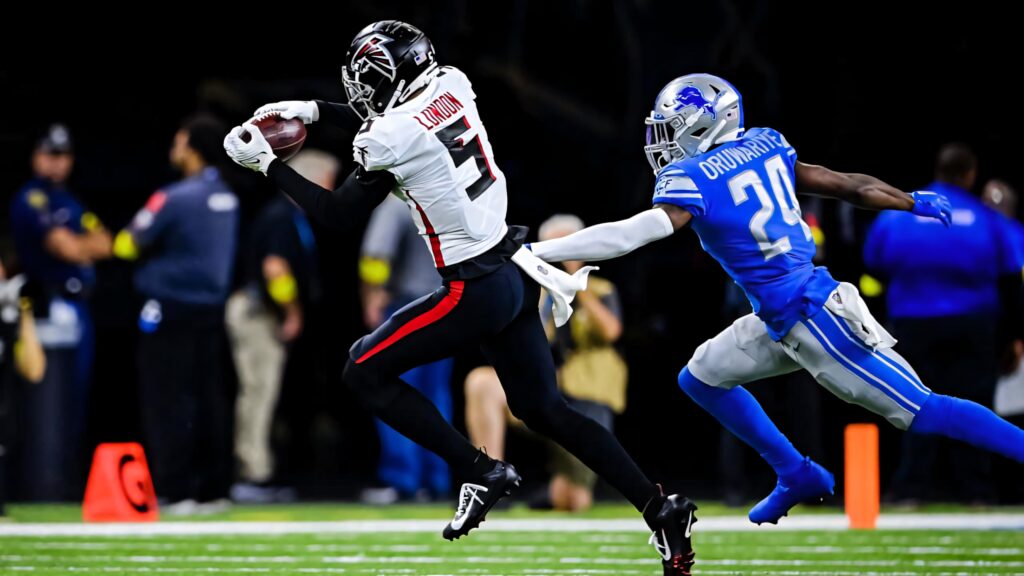 Drake London making dynamic catch against defender in Atlanta Falcons vs Detroit Lions game action Wallpaper