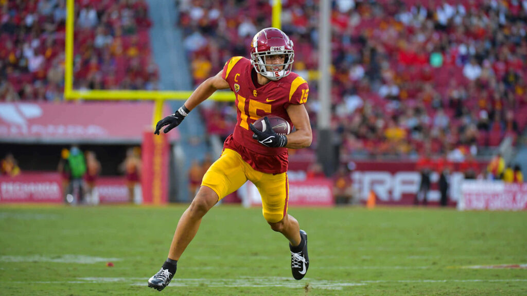 Drake London USC Football player in cardinal gold uniform focused during vibrant college game action Wallpaper