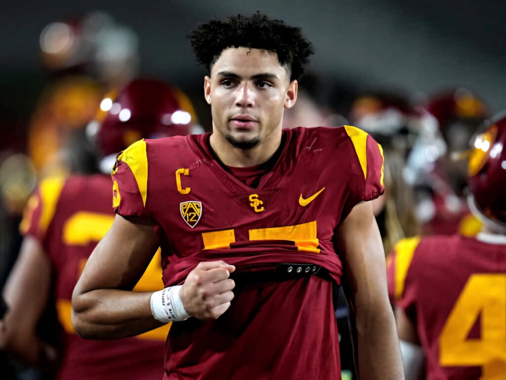 Drake London in USC cardinal and gold uniform showing leadership on stadium football field wallpaper