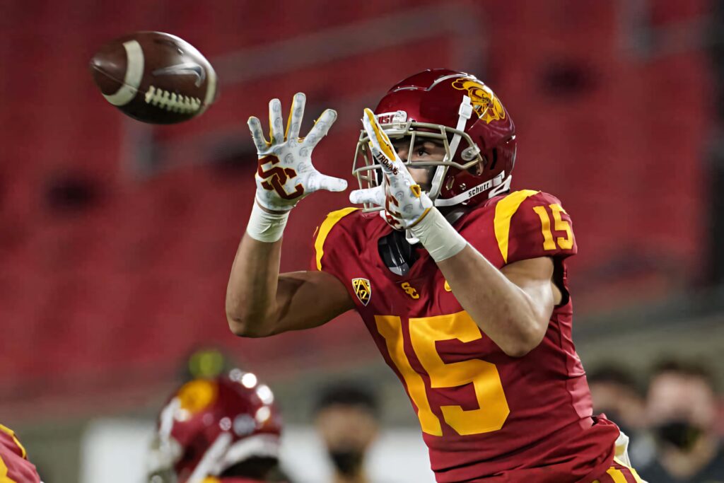 Drake London USC Trojans football player catching ball in red gold uniform blurred stadium background Wallpaper