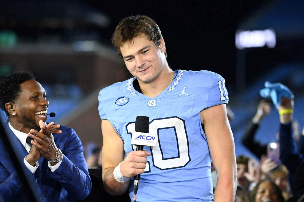Drake Maye in light blue North Carolina jersey smiling during post game football interview on field Wallpaper