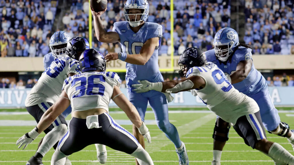 Drake Maye quarterback throws precise pass in intense football game with vivid colors and sharp focus Wallpaper