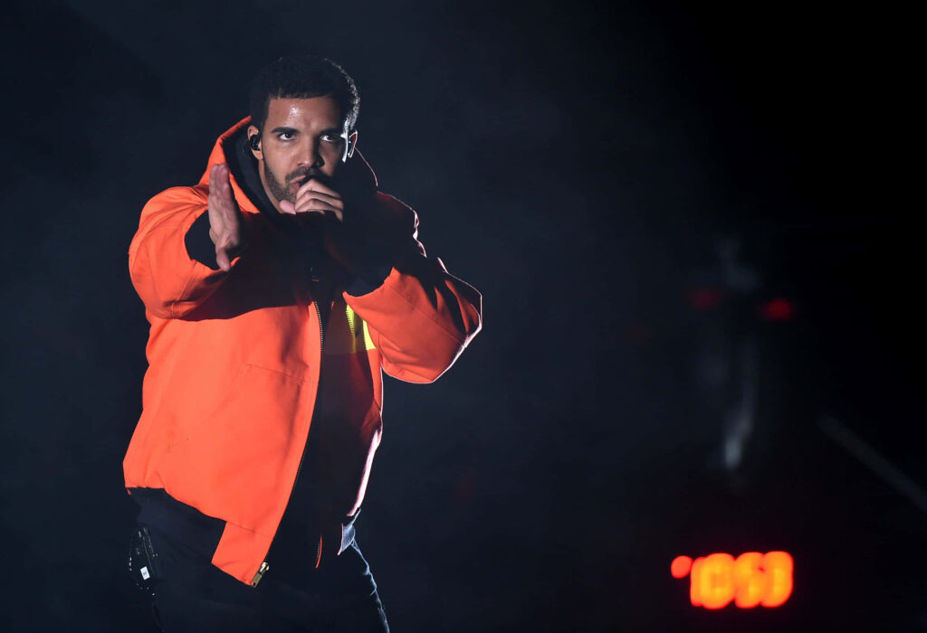Drake Performs in Orange Jacket - Dynamic Stage Wallpaper Background