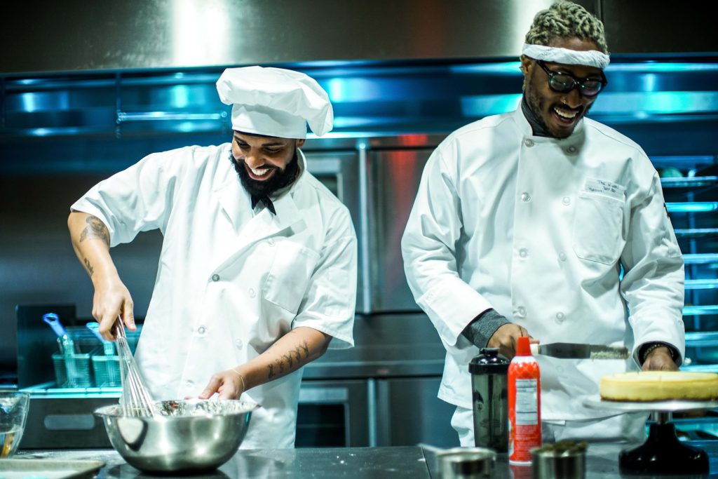 Drake and Future as chefs in white uniforms cooking in commercial kitchen Life Is Good wallpaper