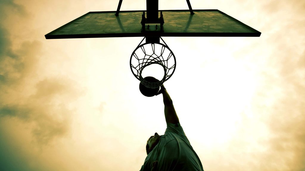 Basketball player dunking silhouette at sunset dramatic high contrast athletic wallpaper background