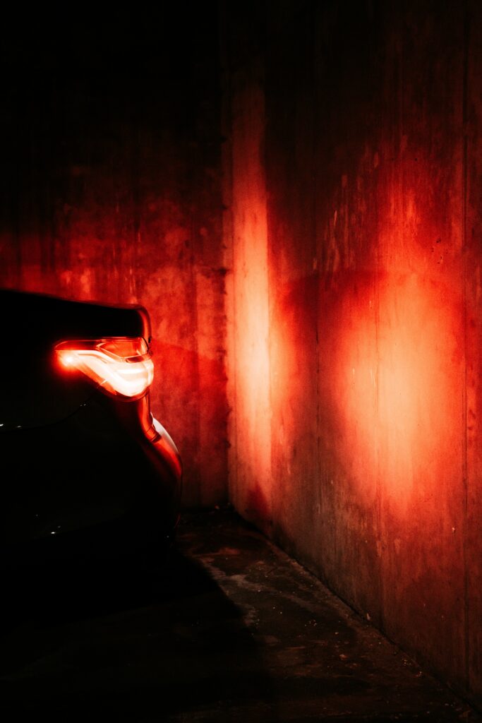 Stunning Black Car Taillight Glow on Textured Concrete Wall Wallpaper