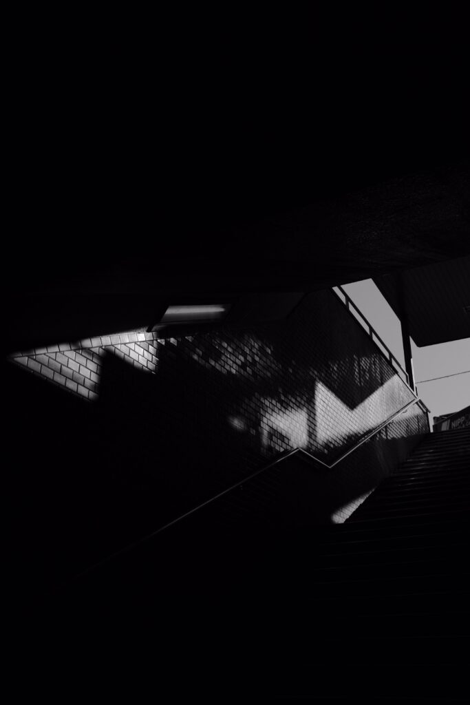 Dimly Lit Black and White Staircase Wallpaper with Shadows