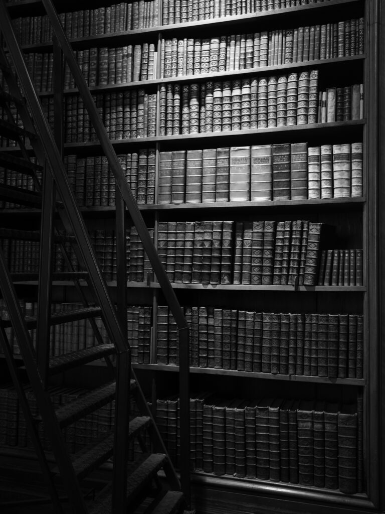Stunning Black-and-White Library Wall with Metal Staircase Atmosphere Wallpaper
