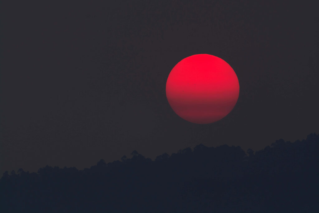 Vivid Blood-Red Sun Wallpaper: Eerie Night Sky with Silhouetted Hills
