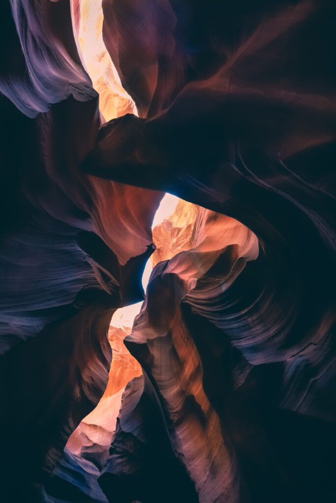 Dramatic canyon wallpaper with layered rocks shafts of light highlighting smooth sandstone formations