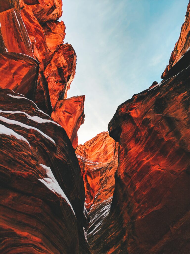 Rugged reddish-orange canyon rock formations under clear blue sky vibrant natural landscape wallpaper