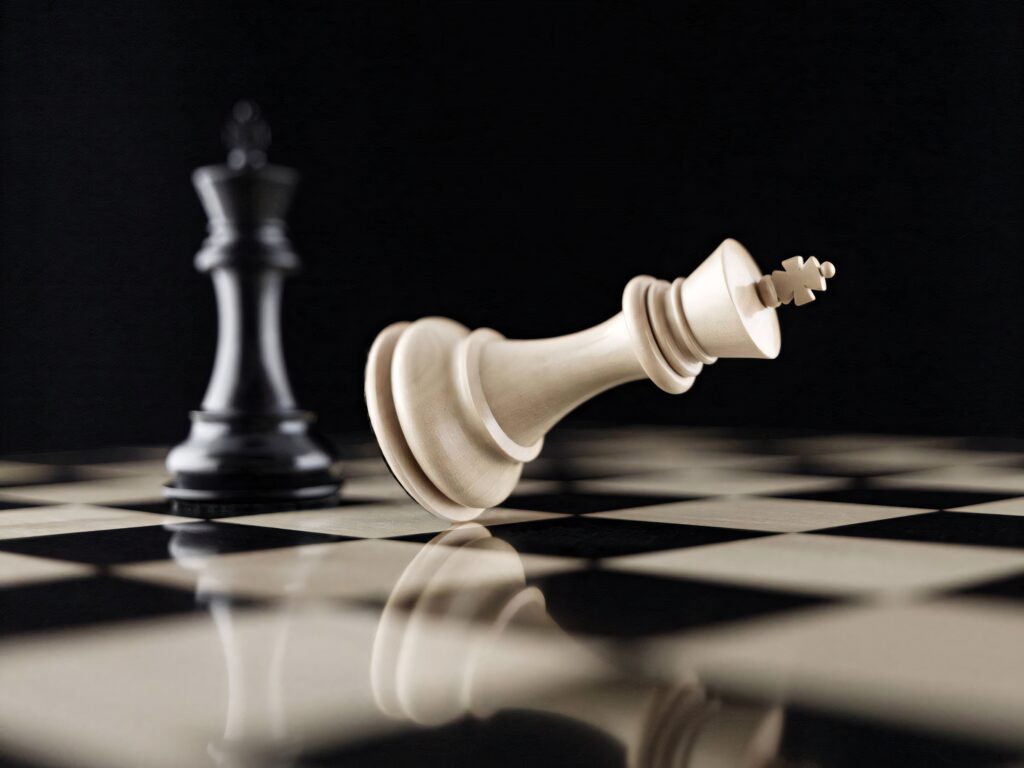 Dramatic chess battle wallpaper with toppled white king and standing black king on glossy board