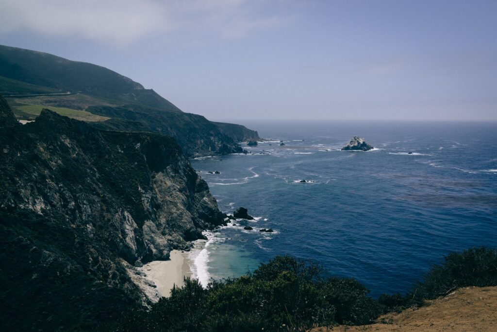 Dramatic coastline with steep cliffs deep blue sea gentle waves rugged rocks scenic wallpaper background