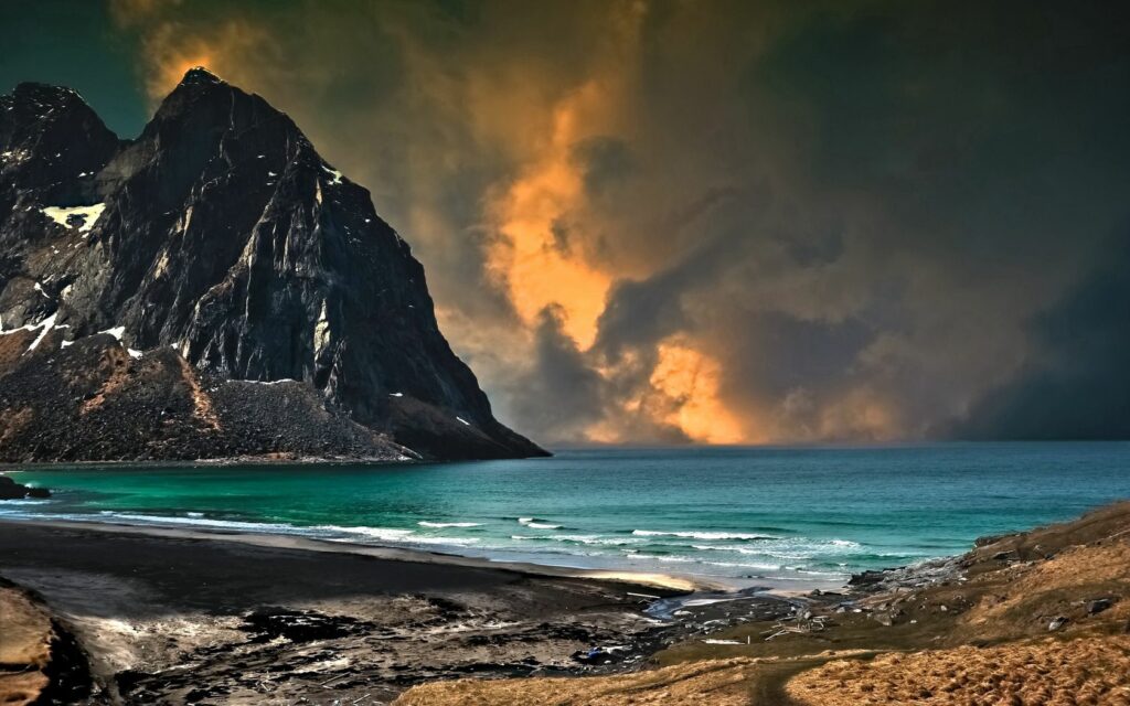 Dramatic coastal wallpaper with rugged mountains turquoise sea and vibrant orange cloudy sky