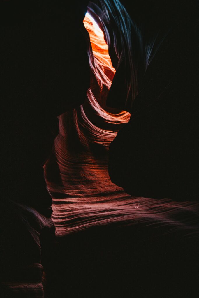 Dark canyon wallpaper with rugged rocks glowing in warm light showcasing textured curves