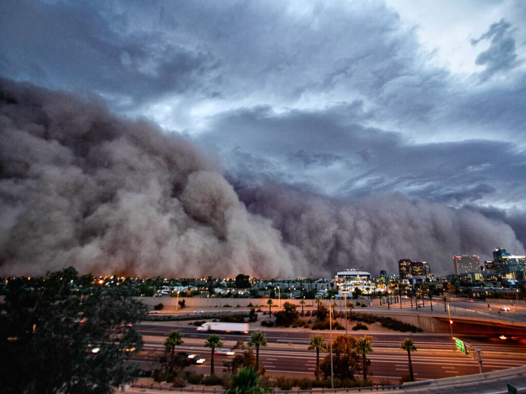 Immense dust storm approaching city skyline under brooding sky at dusk dramatic urban landscape Wallpaper