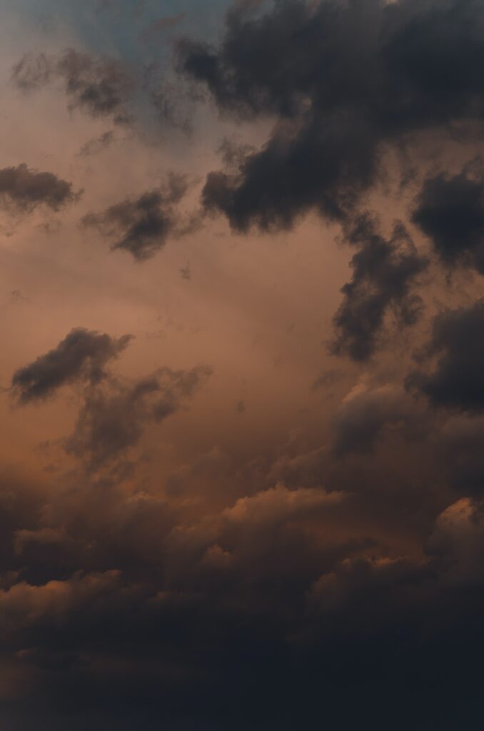 Dramatic evening sky wallpaper with moody clouds in deep orange and subtle blue hues