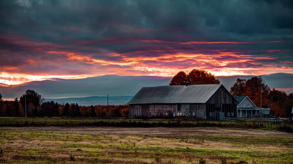 Dramatic fall farm sunset wallpaper with rustic barn farmhouse fiery sky autumn trees field