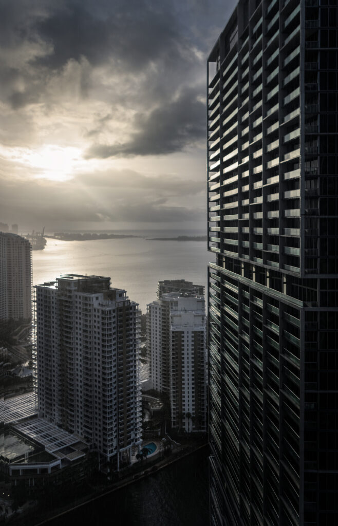 Grayscale Cityscape Wallpaper: Dramatic Aerial View with Sea Backdrop