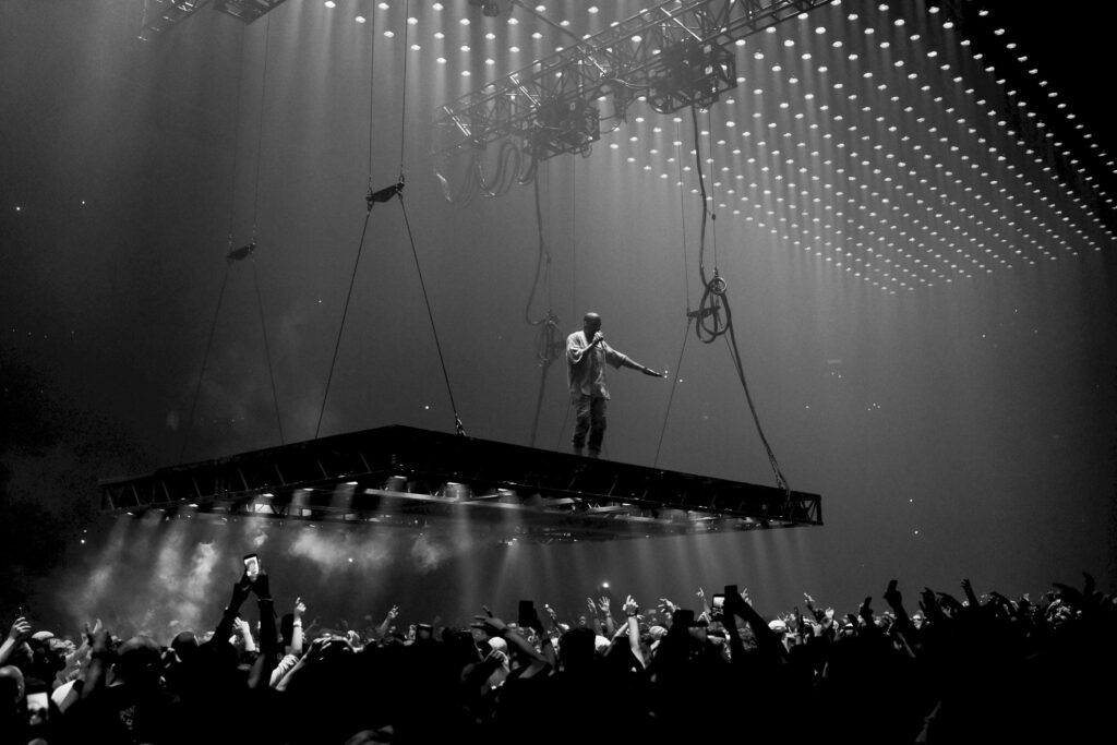 Dynamic Grayscale Concert Wallpaper: Performer Above Cheering Crowd