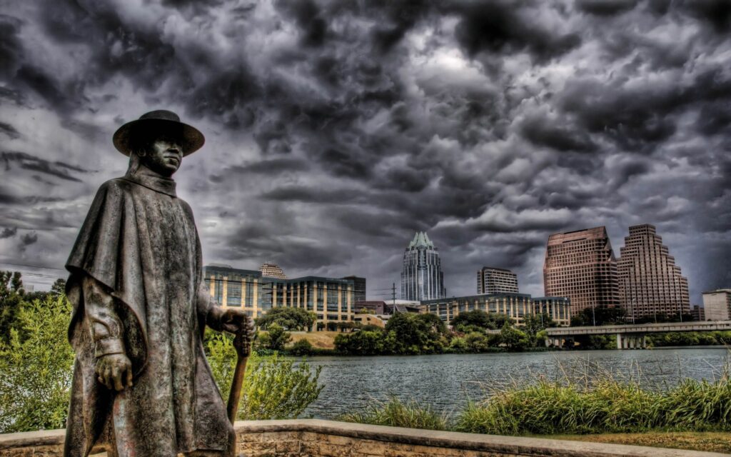 Dramatic HDR Cowboy Statue Wallpaper with Scenic Urban Landscape
