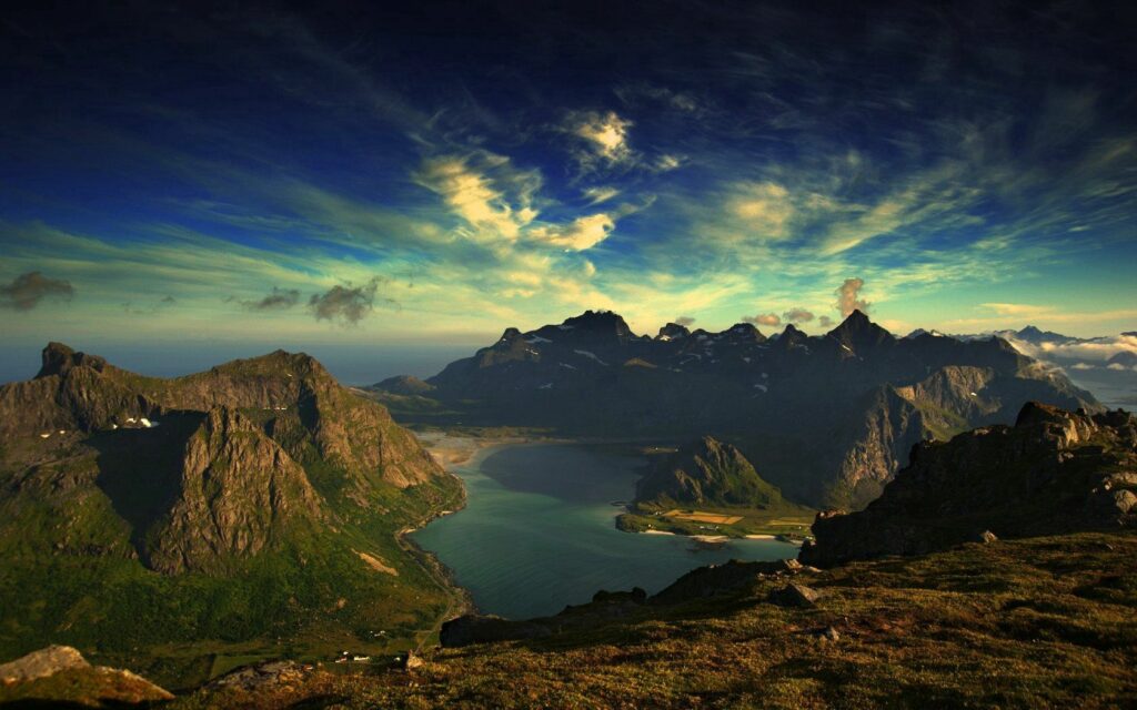 Island wallpaper with rugged mountains green landscape and calm blue ocean under vibrant sky