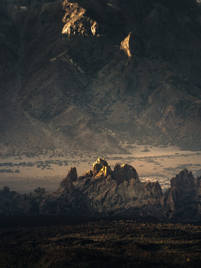 Dramatic mountain landscape wallpaper with rugged rocks earthy tones and soft natural light