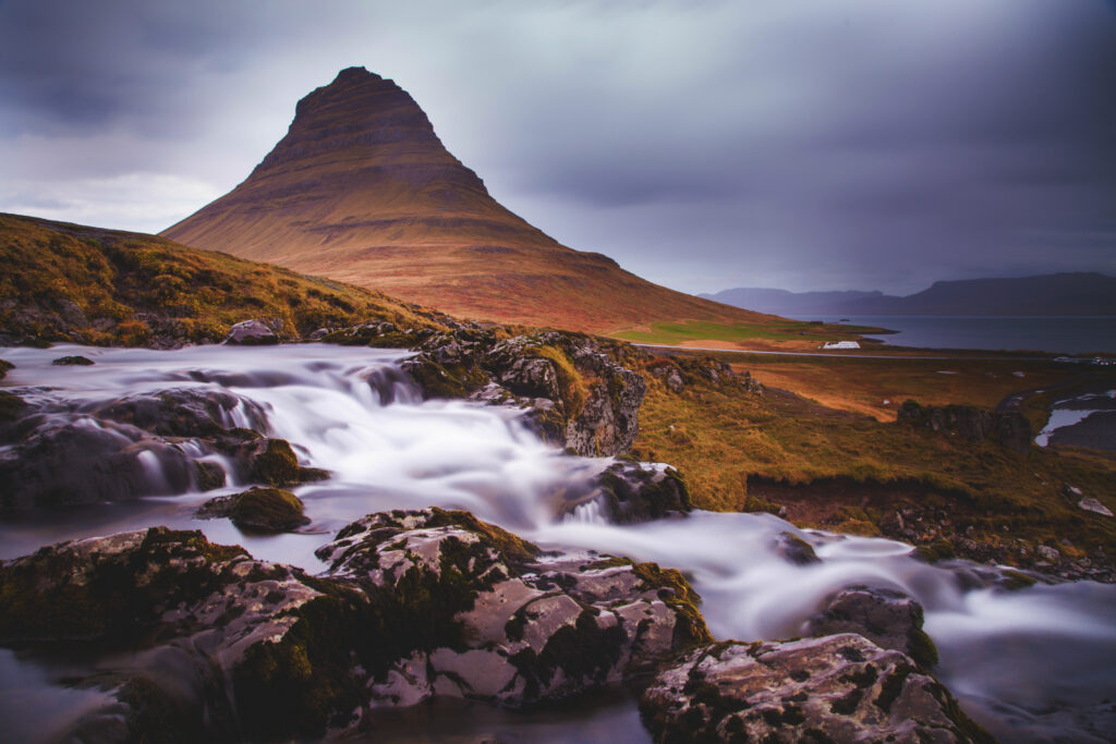Dramatic mountain with moody skies and silky smooth stream in tranquil earthy landscape wallpaper