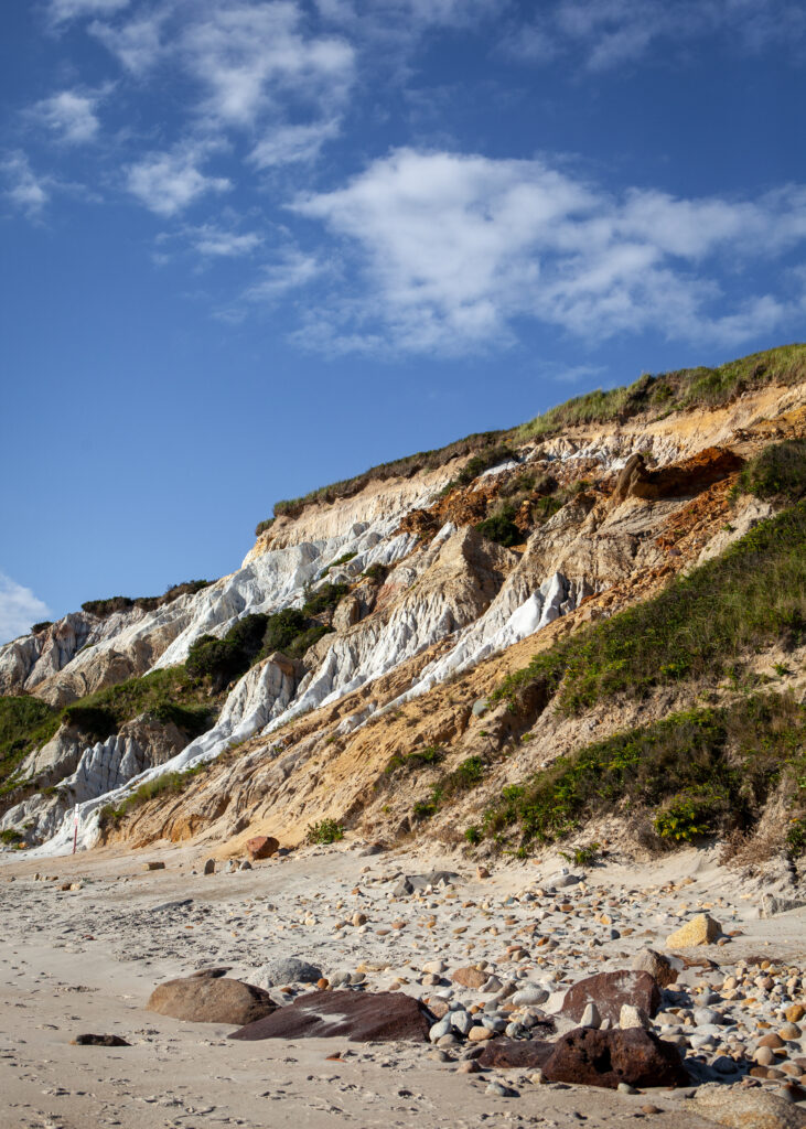Dramatic mountain slope with layered sand stones white golden rocks bright blue sky clouds wallpaper