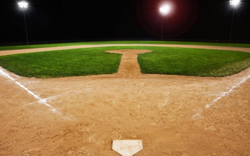 Baseball field at night with bright stadium lights home plate vibrant green grass wallpaper