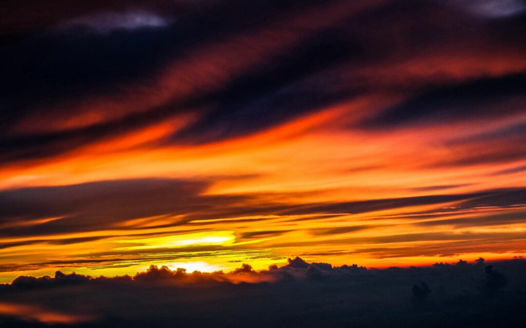 Dramatic night sky wallpaper with golden streaks purple orange yellow clouds atmospheric background