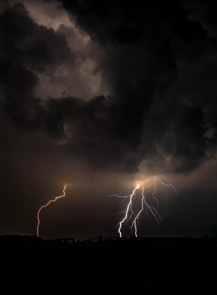 Dramatic nighttime storm with powerful lightning bolts illuminating dark overcast clouds wallpaper