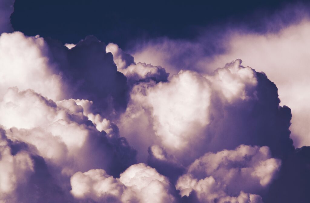 Overcast sky wallpaper with dense violet and white clouds creating a moody tranquil scene