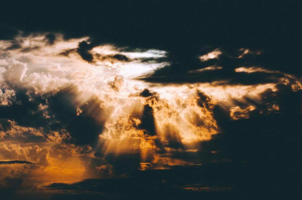 Overcast sky with dramatic clouds illuminated by golden sunlight creating dynamic contrast Wallpaper