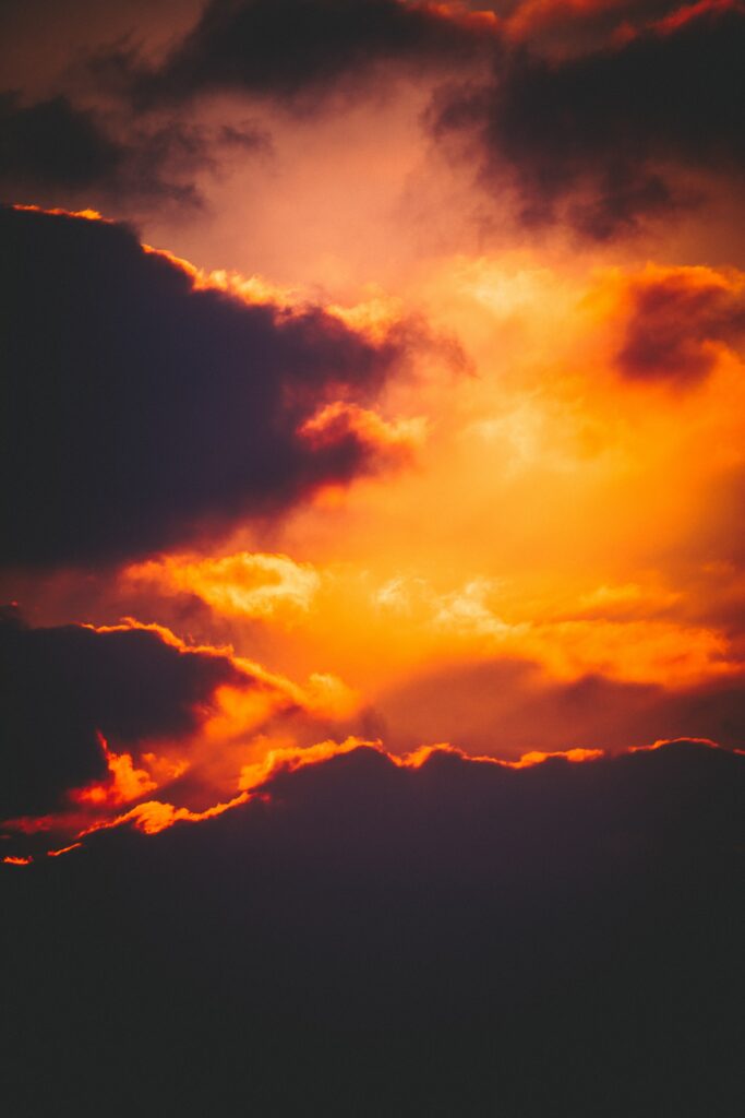 Dramatic overcast sky with vibrant orange and yellow light creating warm dynamic atmosphere Wallpaper