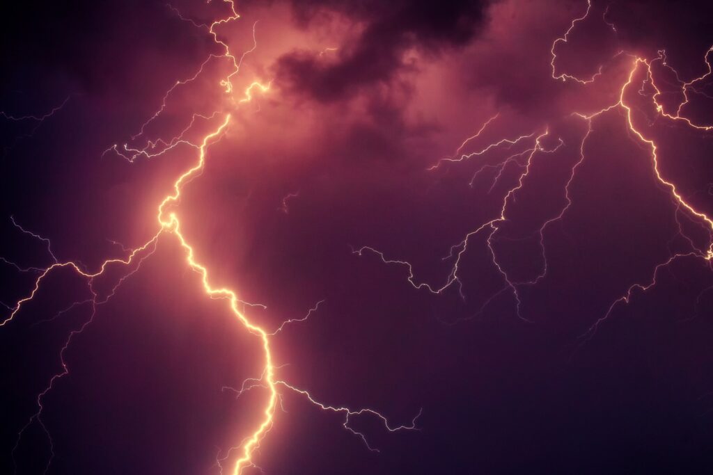Vivid thunderstorm wallpaper with bold lightning bolts in purple and orange turbulent sky
