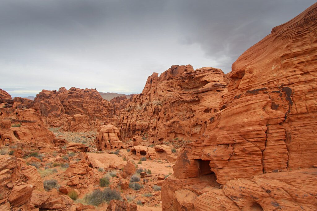 Dramatic red rock canyon landscape with rugged cliffs under cloudy sky wallpaper background