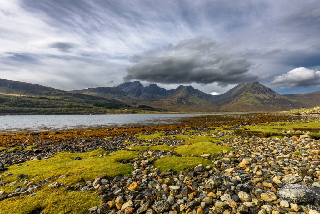 Dramatic rugged mountains sharp peaks rocky coast tranquil river lush green moss wallpaper background
