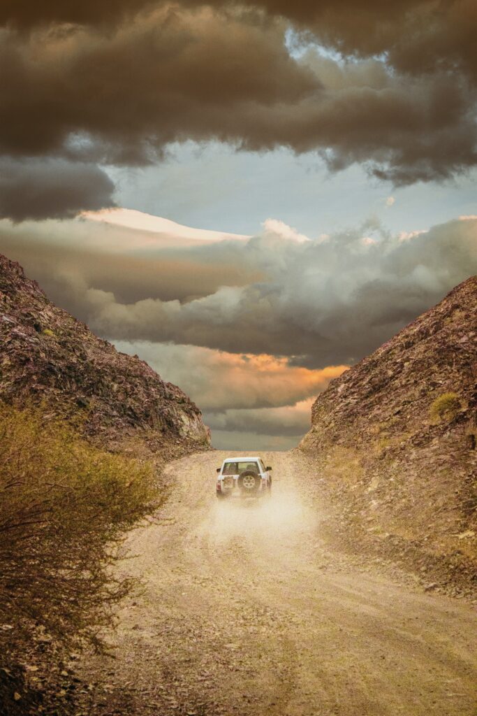 Adventure SUV Wallpaper: Rugged Hills & Dramatic Sky Background