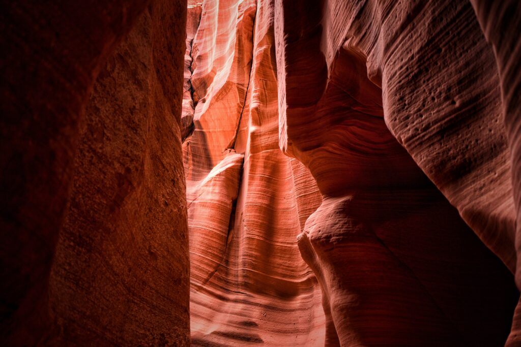 Sandstone canyon cave with warm light highlighting rich orange and red rock textures wallpaper