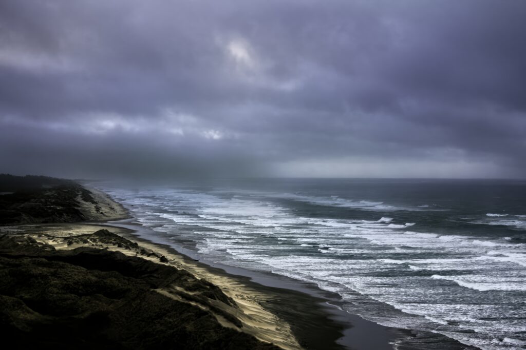 Dramatic seascape with rolling waves frothy sea foam rugged coastline and moody cloudy sky wallpaper