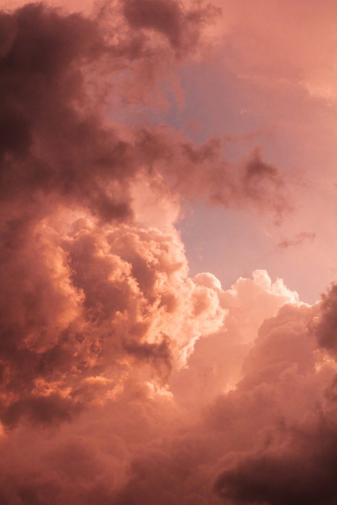 Dramatic sepia sky with textured clouds in warm orange and dusty pink at serene sunset Wallpaper