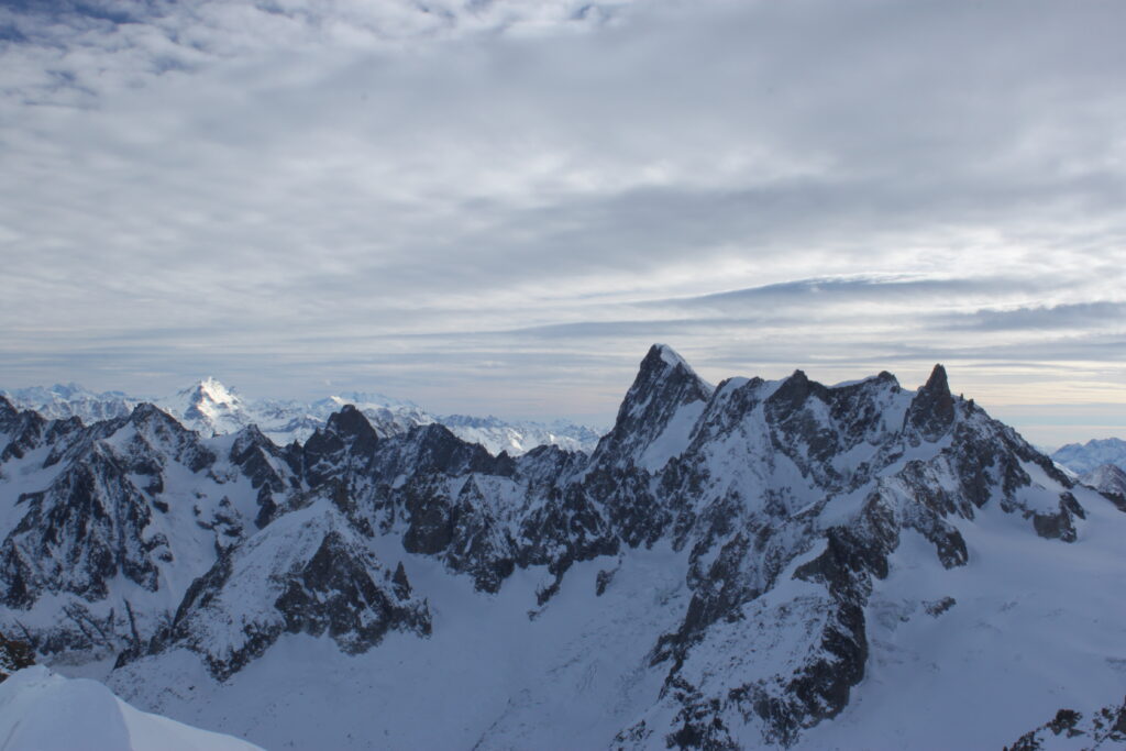 Dramatic snowy mountain peaks under cloudy sky in a pristine alpine winter landscape wallpaper