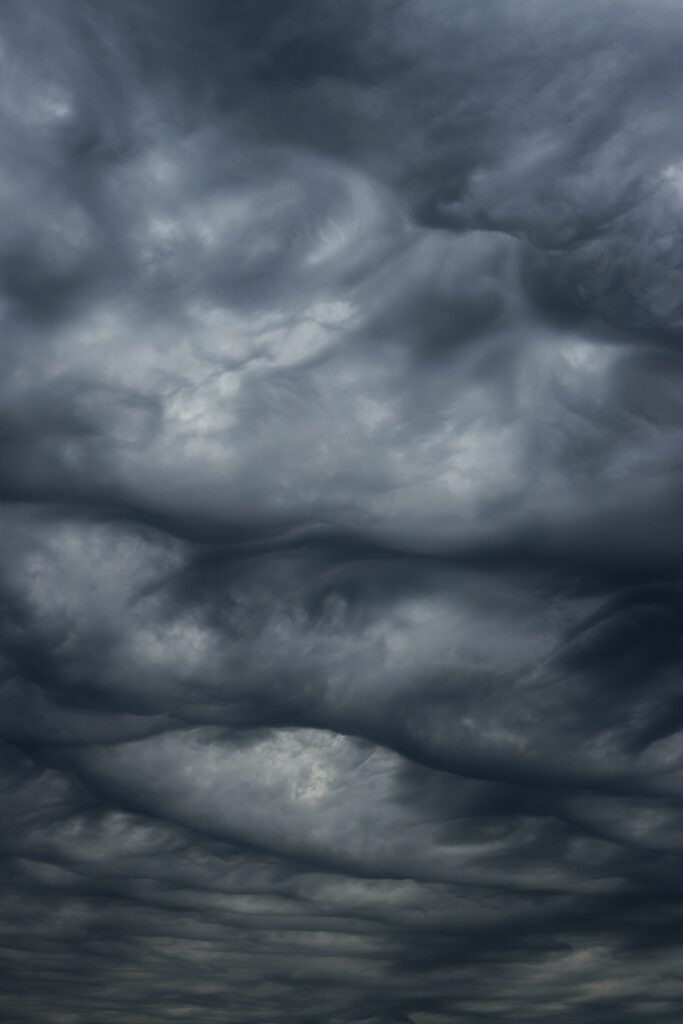 Dramatic stormy sky with swirling dark clouds in deep blues and grays wallpaper background